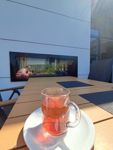 a cup of tea sitting on a plate on a table at Marina Strandbad Chalet Land in Sicht mit Zaun Haus Nr 81 in Olburgen