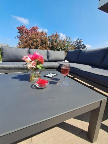 a table with two glasses of wine and flowers on it at Marina Strandbad Chalet Land in Sicht mit Zaun Haus Nr 81 in Olburgen