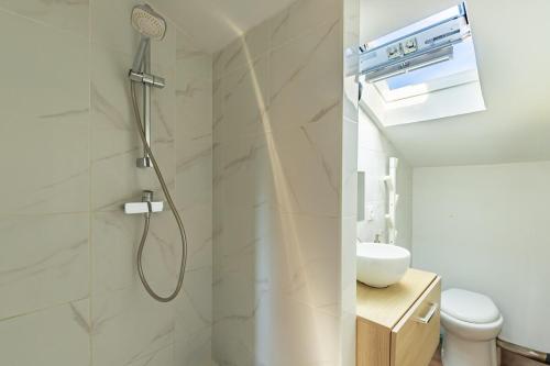 une salle de bain avec douche et lavabo dans l'établissement Les Toits de Roquelaine - Bright & cozy studio, à Toulouse