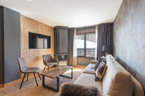 a living room with a couch and a tv at BiBo Suites Sierra Nevada in Sierra Nevada