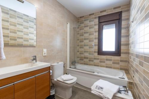 a bathroom with a tub and a toilet and a sink at BiBo Suites Sierra Nevada in Sierra Nevada