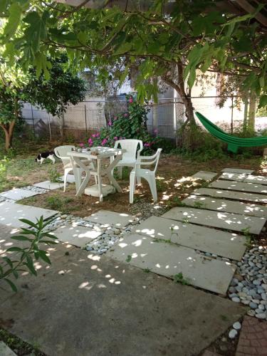 a patio with a table and chairs under a tree at Smal villa loft near the beach in Panayía Mesosporítissa