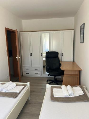 a bedroom with two beds and a desk and a chair at Apartments Purkovic in Vodice