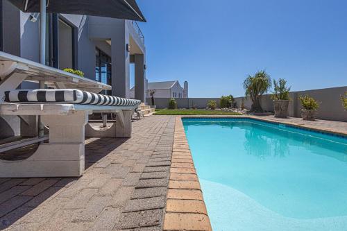 a swimming pool in front of a house at 41 on Park Langebaan in Langebaan