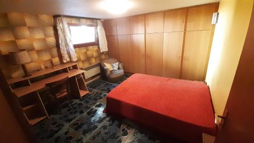 Cette petite chambre comprend un lit rouge et une fenêtre. dans l'établissement Maison meublée spacieuse à la campagne avec jardin, à Gottenhouse