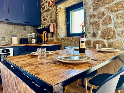 a kitchen with a wooden table with a bottle of wine at Casa das Histórias in Pinhel