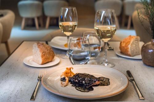 una tavola con piatti di cibo e bicchieri di vino di Barceló Bilbao Nervión a Bilbao