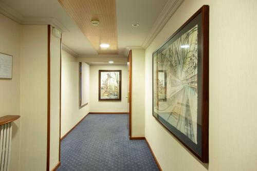 a hallway in a hospital with a large painting on the wall at Best Western Premier Hotel Dante in Barcelona