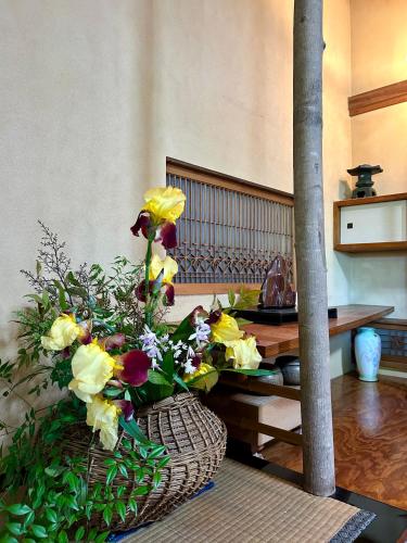 a bouquet of flowers in a basket on a table at Chiba Homestay by Lek บ้านพักใกล้นาริตะโตเกียว in Yotsukaidō