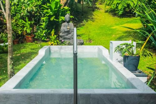a meditation pool with a statue in a garden at Hotel Isla Verde in Boquete