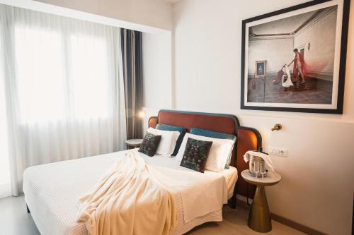 a bedroom with a bed with white sheets and pillows at Art Hotel Milano in Prato