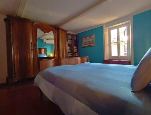 a bedroom with a large white bed and a window at Casa Tipica in Borgo Storico in Dorio