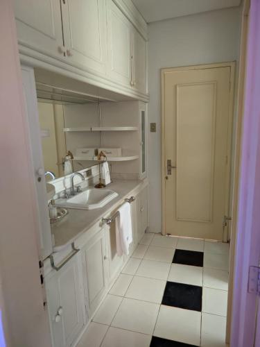 a white bathroom with a sink and a mirror at Pousada Cyprianos in Júlio de Castilhos