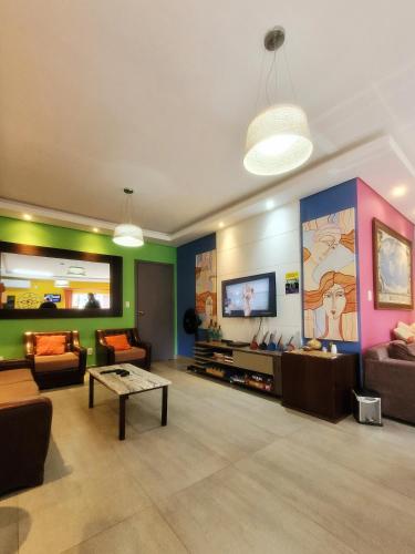 a living room filled with furniture and a flat screen tv at Bonabrigo Hostel & Suítes in Balneário Camboriú