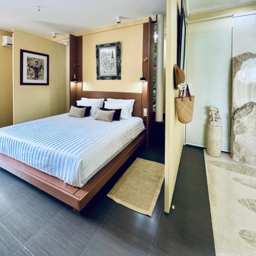 a bedroom with a large bed and a walk in shower at BATI Private Living in Ubud