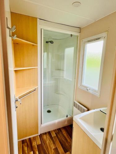 une salle de bain avec douche et lavabo dans l'établissement Mobil-home 159 camping Les Clarines, à La Bourboule