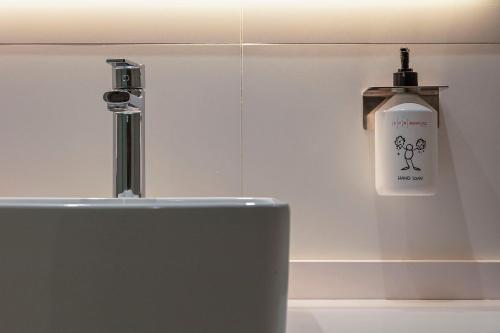 a close up of a sink with a bottle of soap at Aparthotel Bcn Montjuic in Barcelona
