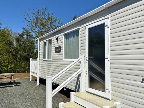 a white caravan with a door and a porch at Linwater Caravan Park - Luxury Lodges and Static Caravans near Edinburgh in Newbridge