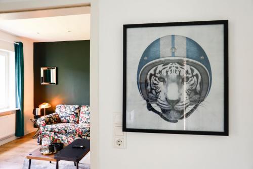 a living room with a picture of a tiger wearing a helmet at Sleephotels Alsterroom in Hamburg