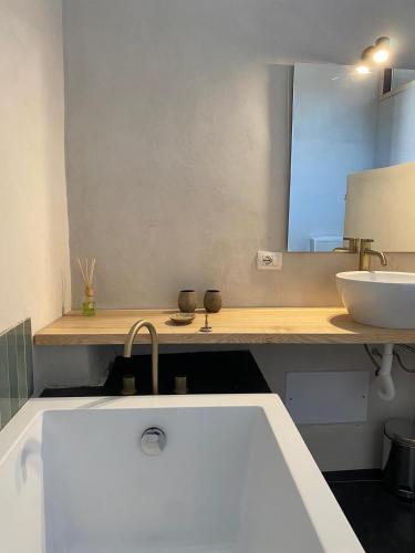 a bathroom with a sink and a white tub at Spacious Studio, lake view and bath in Sorradile