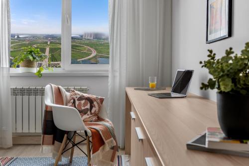 a desk with a laptop computer on it in front of a window at Отель у Ботанического Сада, в самом центре in Astana