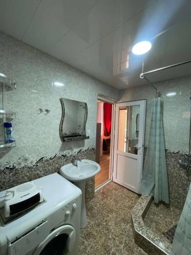 Un baño con lavabo, inodoro y espejo. en Private House, Apartment, en Itʼkhvisi