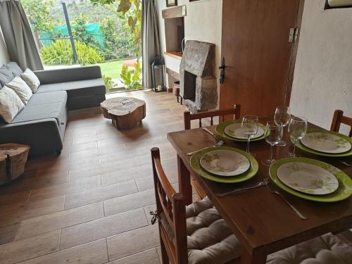 a dining room with a table with plates and wine glasses at El Alpendre- Entre plataneras, a 10 minutos playa in Arucas