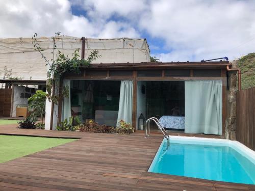 a house with a swimming pool on a wooden deck at El Alpendre- Entre plataneras, a 10 minutos playa in Arucas