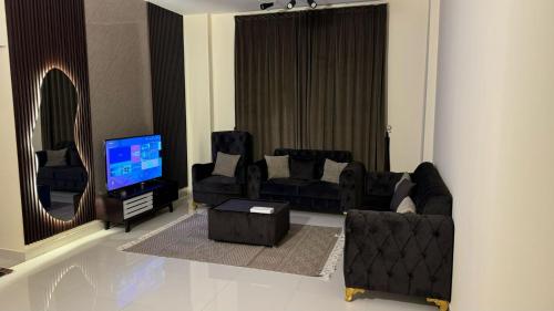 スィーブにあるHammed Apartment Seebのリビングルーム(黒い家具、テレビ付)