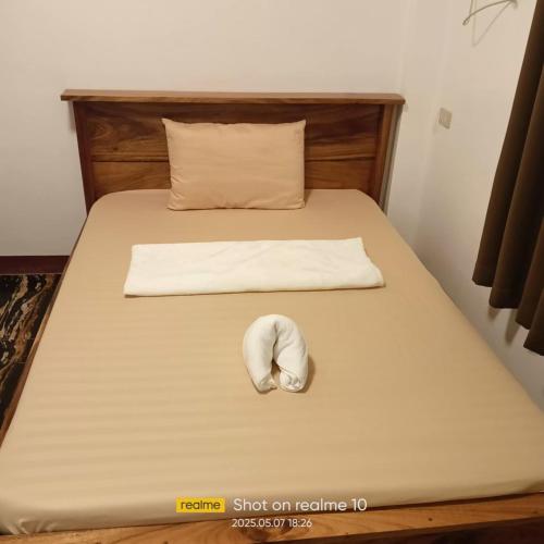 a bed with a pillow and a seashell on it at Leonards Homestay in Coron