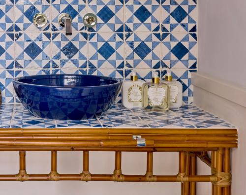 a bathroom sink with a blue bowl on a counter at Pensione America - Adults only in Forte dei Marmi