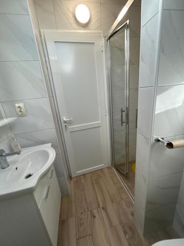 a white bathroom with a shower and a sink at Apartments Purkovic in Vodice