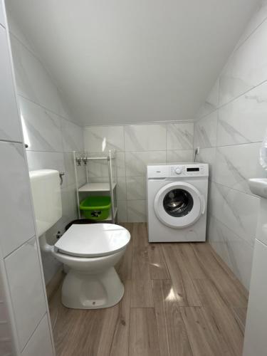a bathroom with a toilet and a washing machine at Apartments Purkovic in Vodice