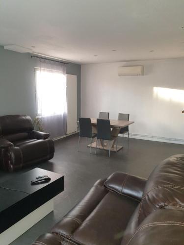 a living room with a couch and a table at Maison 7 personnes in Gouttières