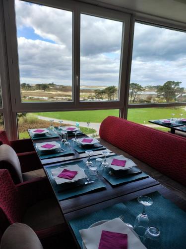een eetkamer met een tafel met wijnglazen bij Auberge Granit Rose - Hébergement partagé en Auberge de Jeunesse - Vue sur mer - Dortoir mixte & Camping in Trébeurden