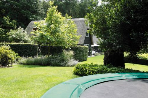a yard with a swimming pool in the grass at Relais & Chateaux Hotel Landgoed Het Roode Koper in Ermelo