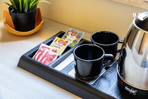 a tray with two cups and a tea kettle on a table at Domus Angeli in Assisi