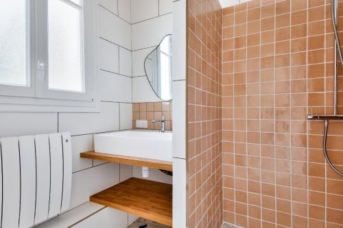 a bathroom with a sink and a mirror at À 220m de la plage, maison avec jardin pour 4 in Le Grand Vieil