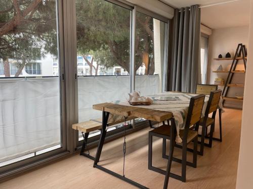 une salle à manger avec une table et des chaises et une grande fenêtre dans l'établissement 60 m2 - 6 people, 3-min walk to Azur beach, à La Grande Motte