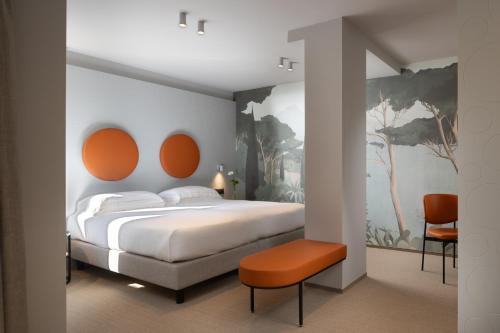 a bedroom with a large bed with orange accents at Hotel Du Lac et Bellevue in Bardolino