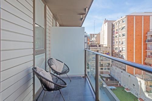 two chairs sitting on the balcony of a building at Aparthotel Bcn Montjuic in Barcelona