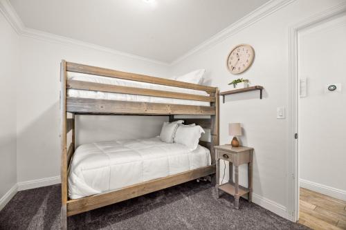 a bedroom with a bunk bed and a clock on the wall at Hummingbird Corner Pet Friendly Great Location Jacuzzi in Big Bear Lake