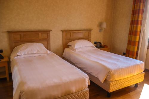 two beds in a hotel room withermottermott at Monica Hotel Fiera in Pregnana Milanese
