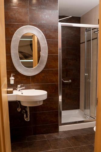 a bathroom with a shower and a sink and a mirror at Hotel Epavlis Eleftheriadi in Paralia Katerinis