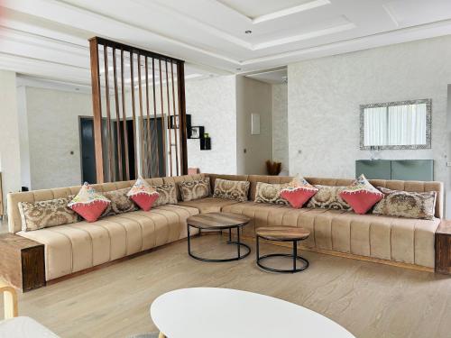a living room with a large couch with pillows on it at Villa Naouma in Marrakech