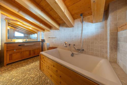 a bathroom with a tub and a sink at Chalet Chafrebelle - sauna & view in Nendaz