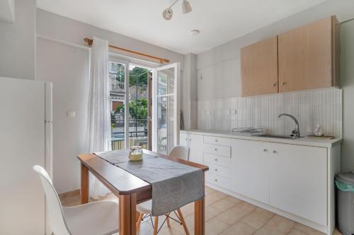 a kitchen with a table and chairs and a sink at Rooms Grapevine in Póros Kefalonias