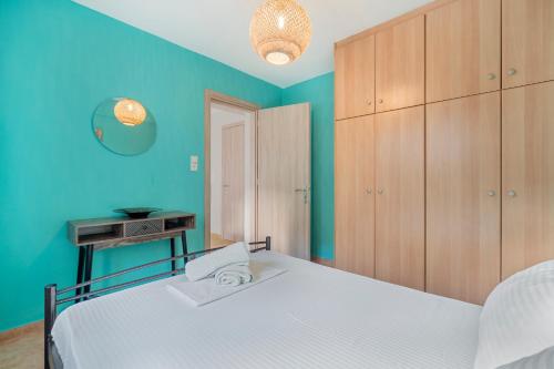 a bedroom with a white bed and blue walls at Rooms Grapevine in Póros Kefalonias
