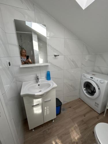 a bathroom with a sink and a washing machine at Apartments Purkovic in Vodice