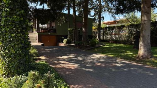 a walkway in front of a house with trees at Pod Świerkami in Boszkowo